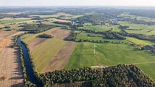 Luftbild mit Feldern, Fluss, Wald, Siedlungen