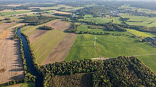 Luftbild mit Feldern, Fluss, Wald, Siedlungen