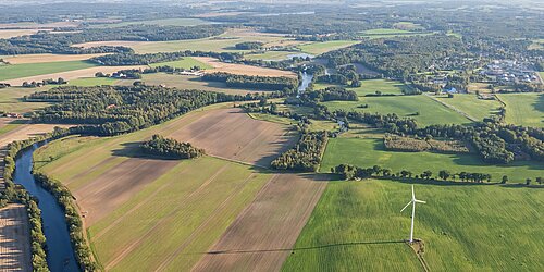 Luftbild mit Feldern, Fluss, Wald, Siedlungen