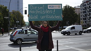 Frau mit Transparent an einer Straße